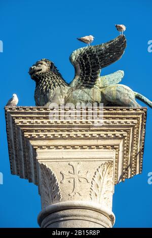 La célèbre sculpture de lion ailé sur la Piazza San Marco (place Saint Marc) sur l'arrière-plan du ciel bleu à Venise, en Italie. Le lion est une symbe Banque D'Images