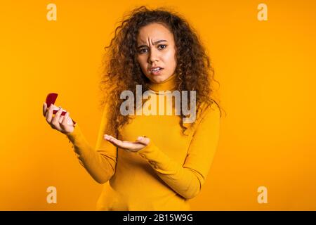 Déçue fille bouleversée, elle n'aime pas le cadeau. Jolie jeune femme de course mixte Banque D'Images