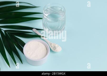 Poudre de collagène en demi-noix de coco avec une cuillère pour mesurer la quantité. Apport en protéines supplémentaire. Banque D'Images