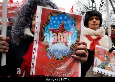Moscou, Russie. 23 février 2020 Participants à un rassemblement et à une marche dans le centre de Moscou marquant le 102ème anniversaire de la fondation de l'armée rouge soviétique et de la marine soviétique. Une femme affiche de la propagande soviétique consacrée à la journée de l'armée soviétique avec l'inscription en russe 'gloire de l'armée soviétique' Banque D'Images