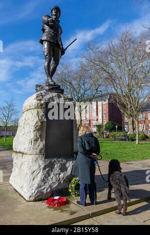 Warrington, Royaume-Uni. 23 février 2020. Lady in black coat with son chien lit la liste des noms sur la statue du portrait de bronze dans Queen's Garden, Palmyra Square, Warrington Town Center est du Lt Colonel W McCarthy O'Leary du South Lancashire Regiment. Le siège de Ladysmith où les Boers et les hauteurs de Tugela devaient être pris. C'était la colline de Pieter dans les hauteurs de Tugela quand le Lt Col McCarthy O'Leary a dirigé le crédit d'accusation : John Hopkins/Alay Live News Banque D'Images