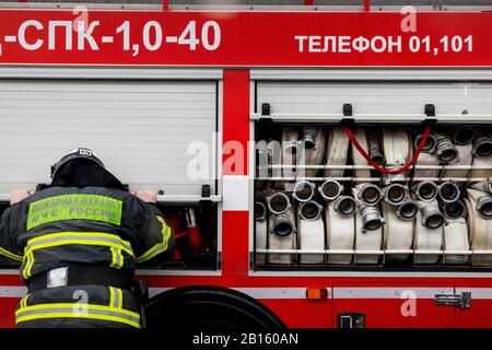 Un travailleur d'urgence ferme la porte latérale d'un camion d'incendie à Moscou, en Russie Banque D'Images