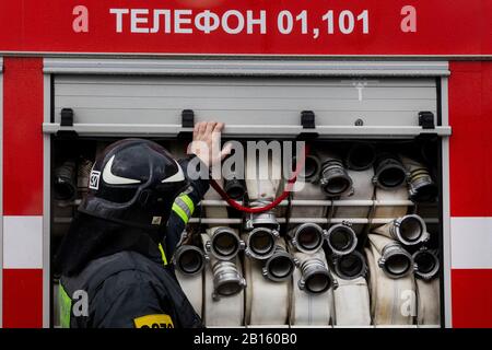 Un travailleur d'urgence ferme la porte latérale d'un camion d'incendie à Moscou, en Russie Banque D'Images