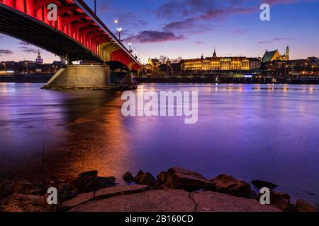 Vue sur la rivière de la vieille ville de Varsovie au crépuscule du soir, capitale de la Pologne, pont éclairé et château royal Banque D'Images