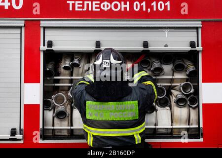 Un travailleur d'urgence ferme la porte latérale d'un camion d'incendie à Moscou, en Russie Banque D'Images