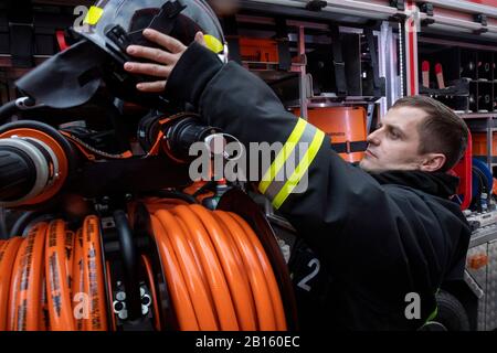 Moscou, Russie. 23 février 2020 un employé du Service des incendies se tient au camion lors d'une démonstration de matériel de tir en l'honneur du 30ème anniversaire du Ministère des Situations d'urgence à VDNKh à Moscou, Russie Banque D'Images