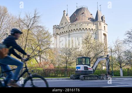 Printemps à Bruxelles. Vue sur la route de réparation de la voile de la pelle hydraulique devant la porte de Halle, la porte médiévale fortifiée de la ville, avec un homme à vélo Banque D'Images