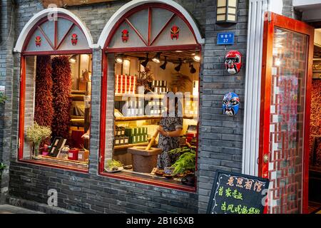 Femme meulant des herbes dans la boutique de médecine chinoise traditionnelle dans le Quartier commerçant de Chengdu Wide and Narrow Aleys Banque D'Images