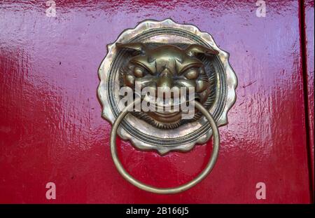 Porte en bronze knocker sur la porte rouge de la salle d'assemblée de Fukian ou de Phuc Kien dans la ville ancienne de Hoi An dans la province de Quang Nam au Vietnam Banque D'Images