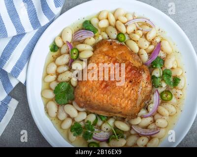 cuisse de poulet cuite avec haricots blancs en assiette Banque D'Images