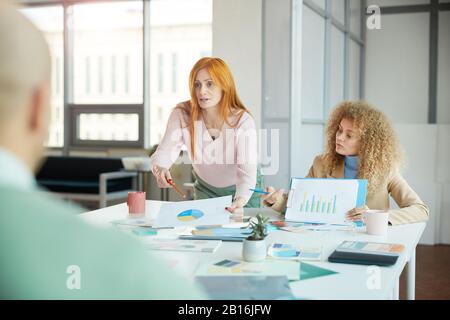 Portrait de deux femmes d'affaires assis en face de deux hommes tout en négociant un accord, copier l'espace Banque D'Images