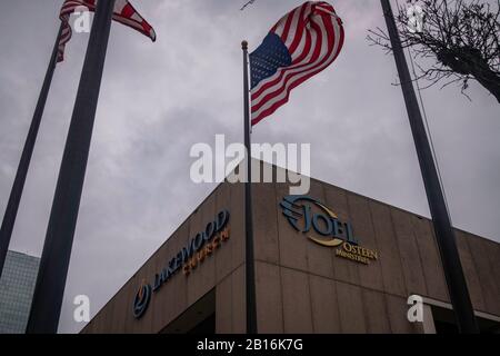 Houston, Texas - 11 février 2020: Drapeau américain sous les nuages de tempête près de l'église de Lakewood Mega de Joel Osteen Banque D'Images