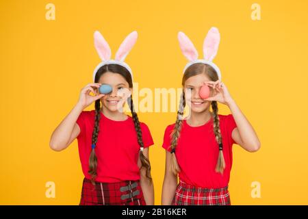 Mignons petites filles portant des oreilles de lapin. Composition de Pâques. Chasse aux œufs. Vacances de printemps traditionnelles. Joyeuses pâques. Printemps à venir. Enfants de lapins de Pâques. Les enfants jouent dans les oreilles de lapin. Banque D'Images