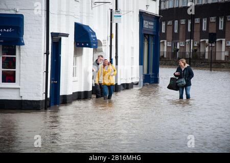 Les résidents qui traversent l'eau à Longden Coleham pendant les inondations de River Severn à Shrewsbury, dans le Shropshire, en Angleterre. Février 2020 Banque D'Images