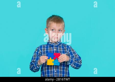 Un petit enfant portant un symbole de puzzle de la sensibilisation du public au trouble du spectre autiste. Journée Mondiale De Sensibilisation À L'Autisme. Banque D'Images