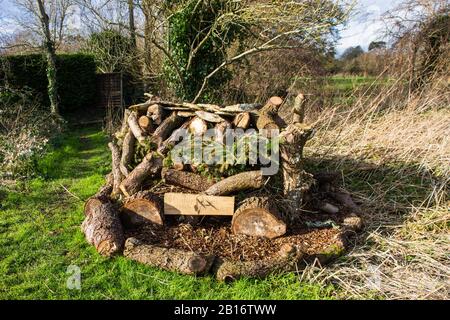 Bug Hotel. Une construction de grumes, de branches et de copeaux fabriqués par un club de jeunes local pour fournir un environnement adapté aux insectes sauvages à Holt Wilts Banque D'Images