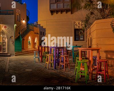 Café-bar avec tables et chaises colorées illuminées la nuit sur une petite place dans la ville de el Gouna, Egypte, 17 janvier 2020 Banque D'Images