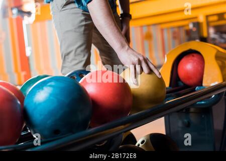 vue partielle de l'homme choisissant le bowling dans le club de bowling Banque D'Images