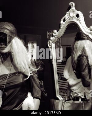 Mannequin féminin réfléchi sur un miroir vintage dans une fenêtre de magasin. Banque D'Images