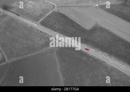une voiture rouge d'en haut dans un paysage agricole noir et blanc Banque D'Images