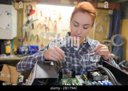 l'assistant de laboratoire femelle répare le module pcb pour la robotique cnc Banque D'Images