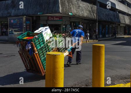 Un homme tire un chariot chargé de produits dans la capitale de San José, Costa Rica. Banque D'Images