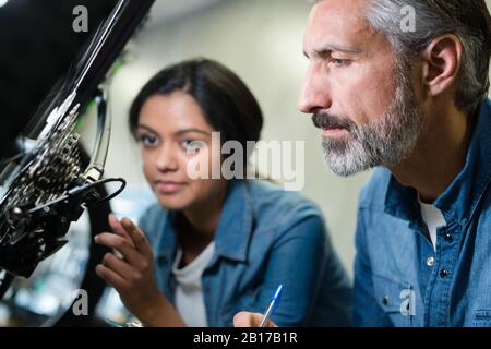 La femme et l'homme comme la mécanique vélo à l'atelier Banque D'Images