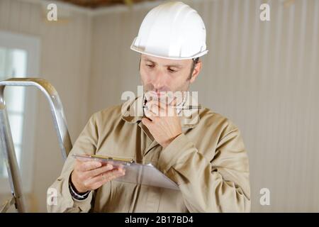 homme constructeur travaillant sur presse-papiers Banque D'Images