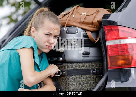 avoir du mal à mettre des valises dans une voiture Banque D'Images