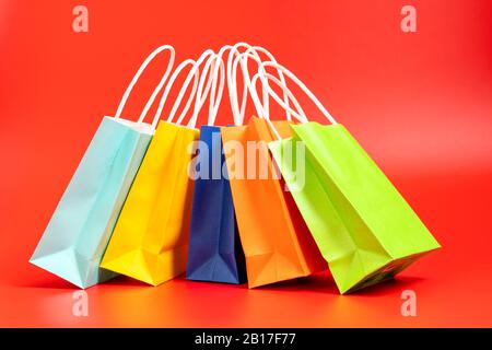 Sacs de shopping ou de cadeaux colorés isolés en rouge Banque D'Images