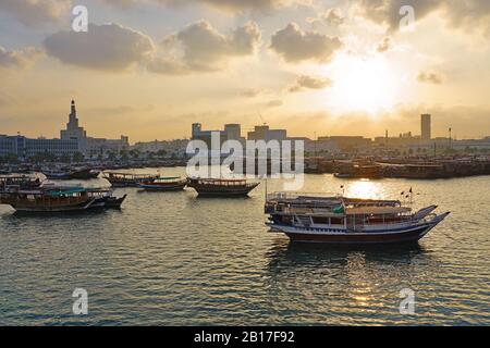 Doha, QATAR -12 DEC 2019 - vue au coucher du soleil sur les bateaux en bois traditionnels de Dhow dans l'eau devant le centre culturel islamique Abdulla Bin Zaid Al Mahmoud Banque D'Images