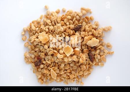 Muesli avec noix de raisins secs et fruits confits. Séchez le mélange de granola sur une vue de dessus d'arrière-plan blanche. Banque D'Images