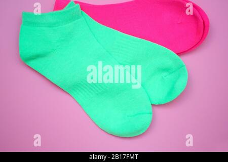 Chaussettes de sport vert clair vue du dessus. Chaussettes lumineuses pour Femme sur un fond rose. Chaussettes basses en coton naturel. Banque D'Images