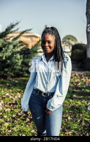Portrait de la jeune femme souriante avec des tresses noires Banque D'Images