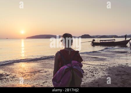 Vue arrière de la femme sur la plage au coucher du soleil, Noppharat Thara Beach, Ao Nang, Krabi, Thaïlande Banque D'Images