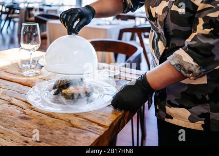 Femme servant un plat au restaurant Banque D'Images