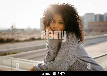 Portrait d'une belle jeune femme sur un toit au coucher du soleil Banque D'Images