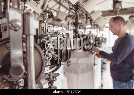 Vue floue de l'homme travaillant dans une usine de textile Banque D'Images