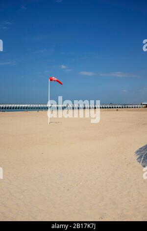 Belgique, Ostende - Windsock sur la plage avec jetée en arrière-plan Banque D'Images