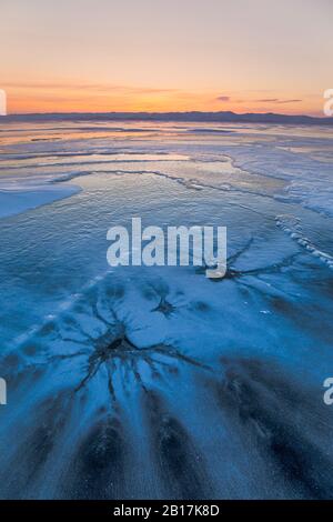 Lever du soleil d'hiver sur la glace de lac avec des formations de glace intéressantes. Lac Baikal, Sibérie, Russie. Banque D'Images