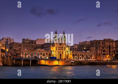 Malte, St Julian, ville de la nuit avec l'église Carmelite à Balluta Bay Banque D'Images