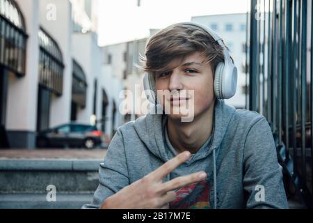 Portrait de l'adolescent avec casque montrant le signe de victoire Banque D'Images