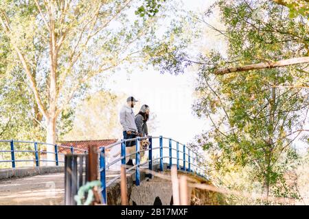 Un couple avec leur chien debout sur un pont dans un parc Banque D'Images