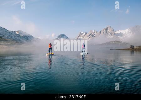 Deux femmes se tiennent debout paddle surf sur un lac Banque D'Images