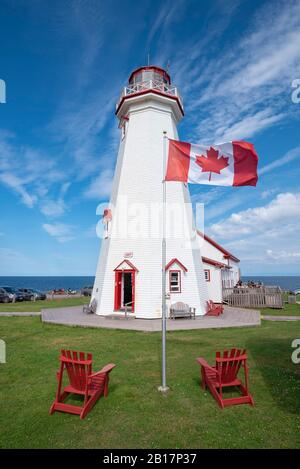 Canada, Île-du-Prince-Édouard, Elmira, drapeau canadien devant le phare de East point Banque D'Images