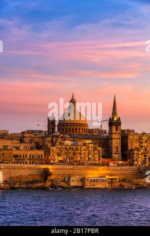 Malte, la Valette, les gratte-ciel de la ville au coucher du soleil, les bateaux dans le port de Marsamxett en premier plan Banque D'Images