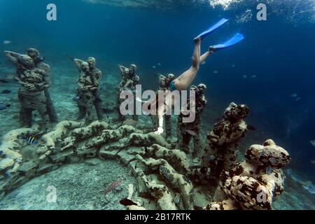 Femme nageant près de la sculpture sous-marine réalisée par Jason deCaires Taylor, île de Gili Meno, Bali, Indonésie Banque D'Images