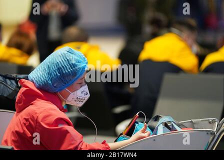 (200224) -- BEIJING, 24 février 2020 (Xinhua) -- le membre de l'équipe médicale Wang Hong, portant un masque de visage écrit avec des mots encourageants de sa fille, a un chat vidéo avec sa famille avant de partir pour Hubei à l'aéroport international Harbin Taiping à Harbin, dans le nord-est de la Chine Heilongjiang province, 23 février 2020. Le huitième groupe d'équipes médicales composé de 201 membres du personnel médical de la province de Heilongjiang est parti dimanche pour la province de Hubei afin d'aider à lutter contre la nouvelle épidémie de coronavirus (COVID-19). Jusqu'à présent, Heilongjiang a dépêché quelque 1 533 médecins à Hubei. ( Banque D'Images