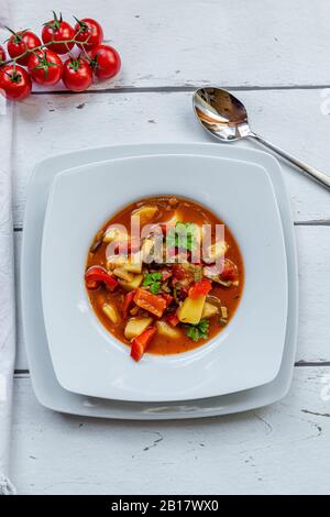 Assiette de goulash de légumes avec pommes de terre, poivron, tomates, poireaux et persil Banque D'Images