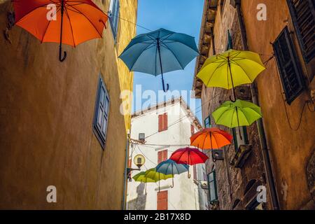 Croatie, Istrie, Labin, vue à bas angle des parasols colorés pendent dans la ruelle de la vieille ville Banque D'Images